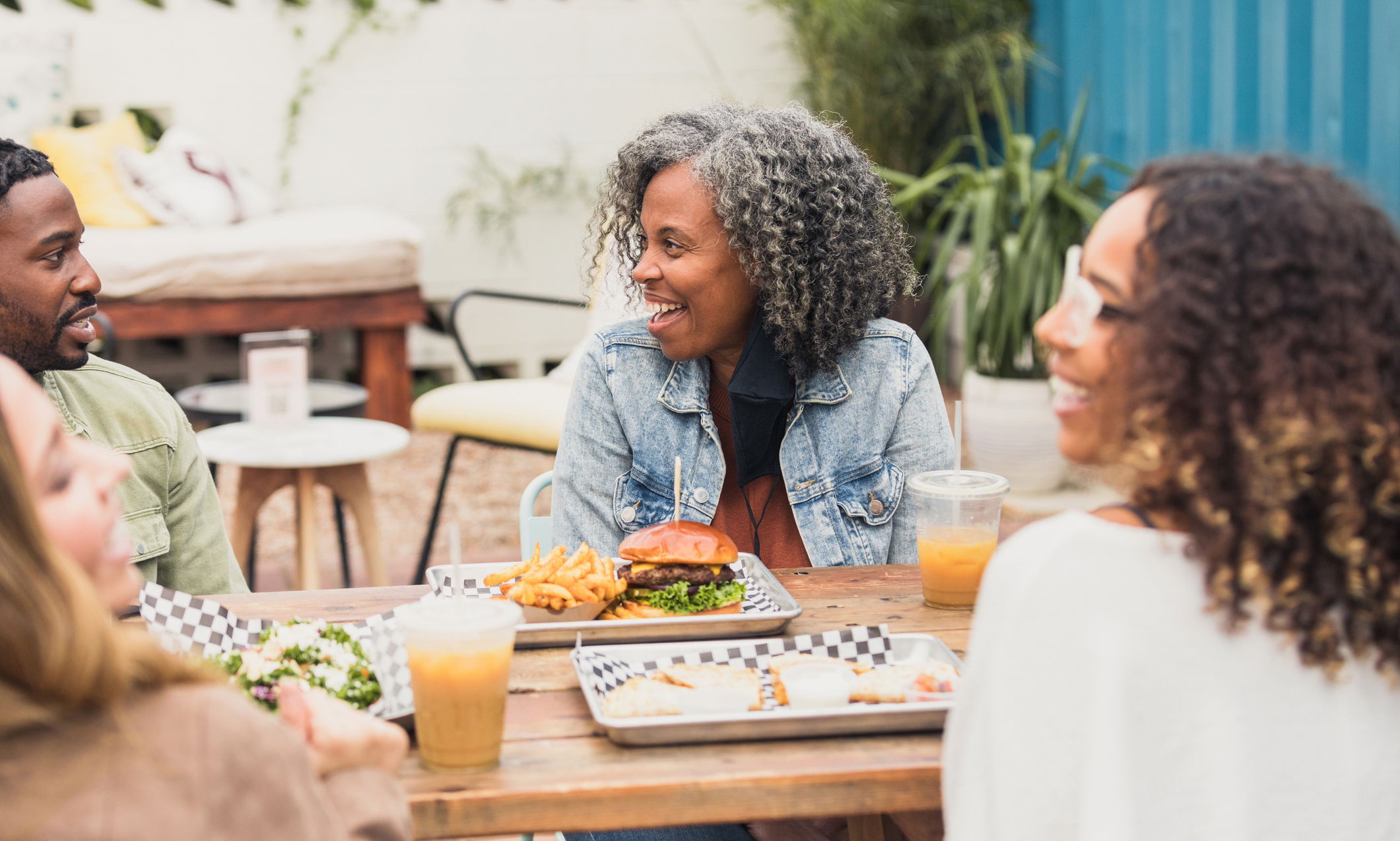 A multi-ethnic group of colleagues meet at a patio restaurant.