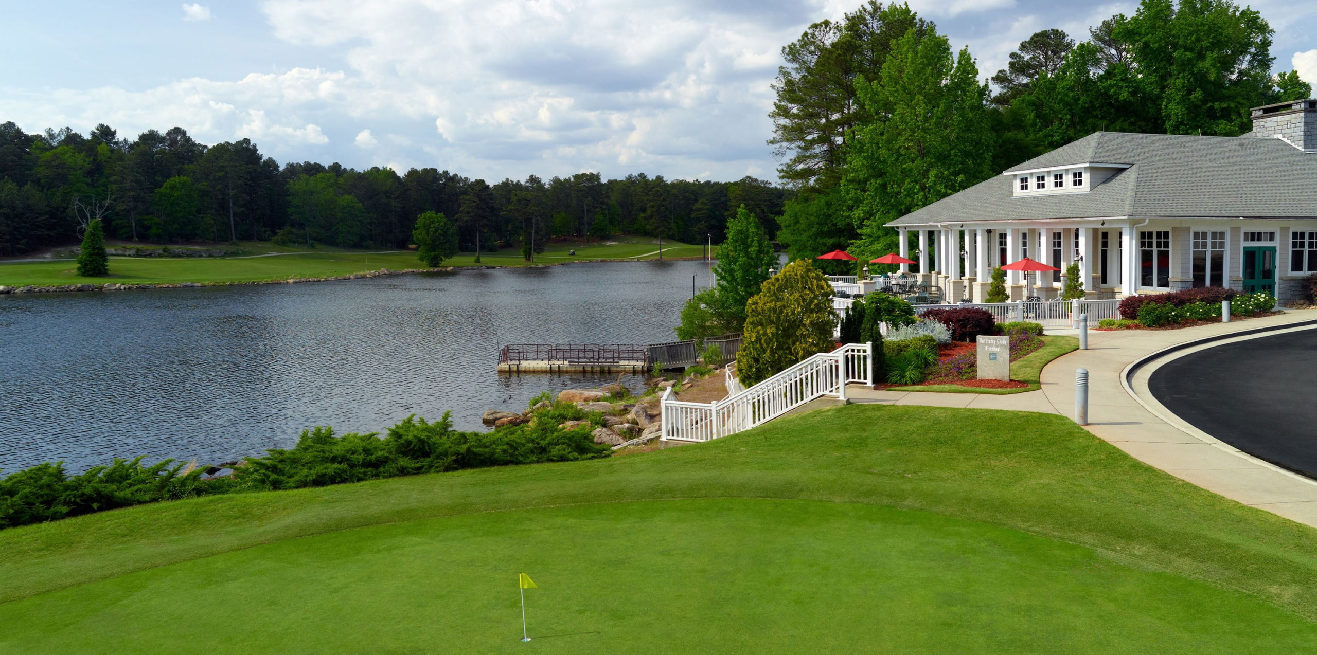 golf course with a club house and lake in the background