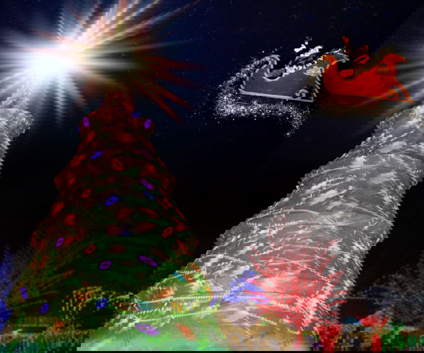 Santa in red sleigh flying over holiday tree